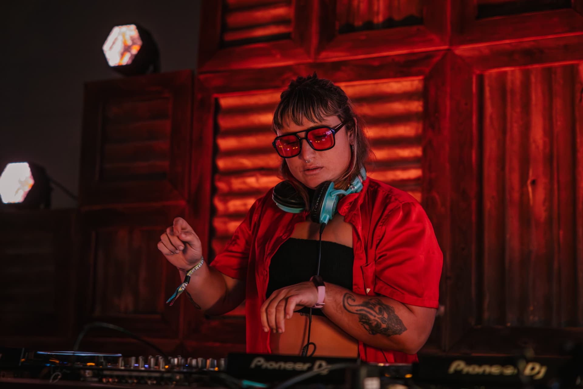 DJ in red light behind the decks