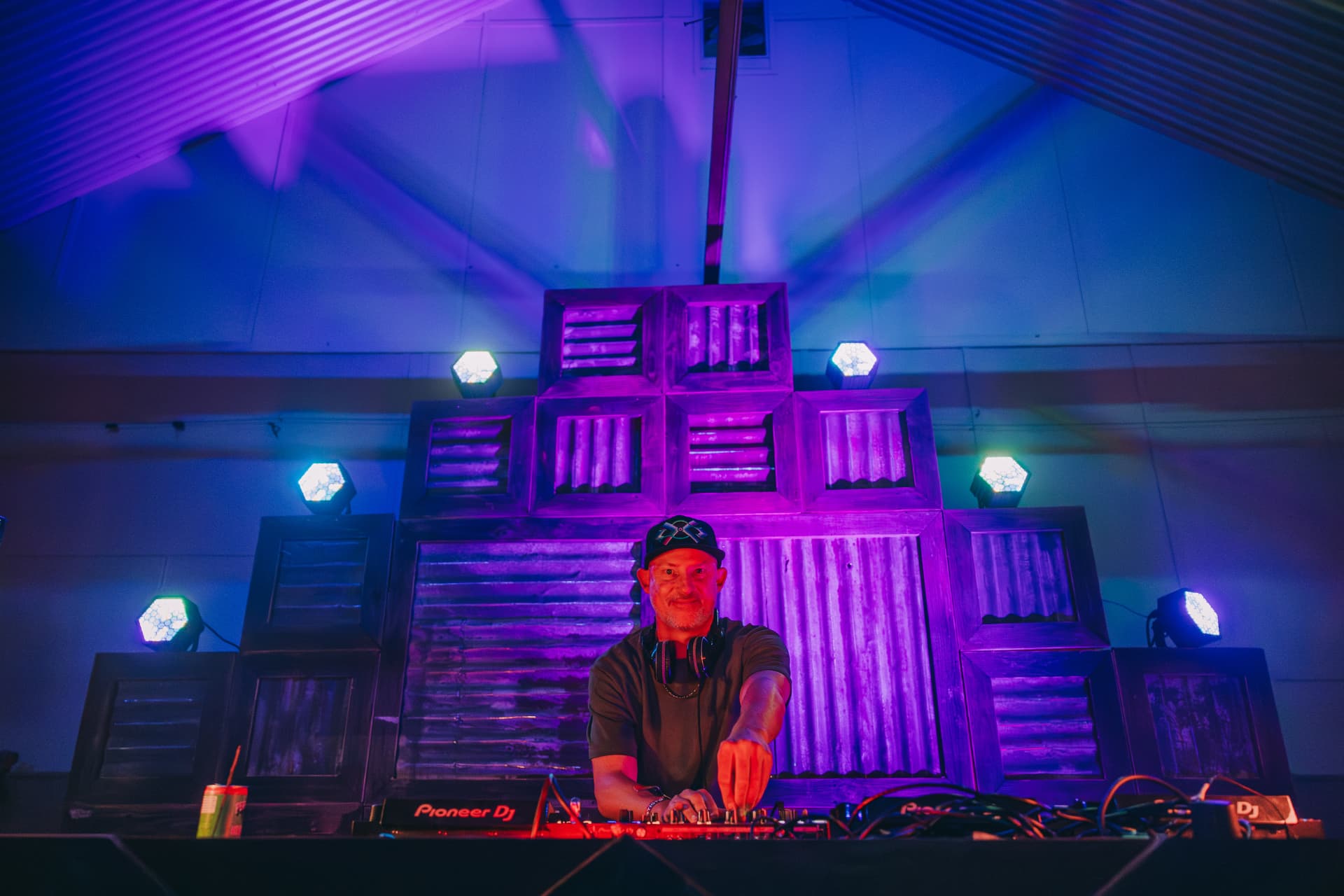 DJ performing in the blue-lit shed stage
